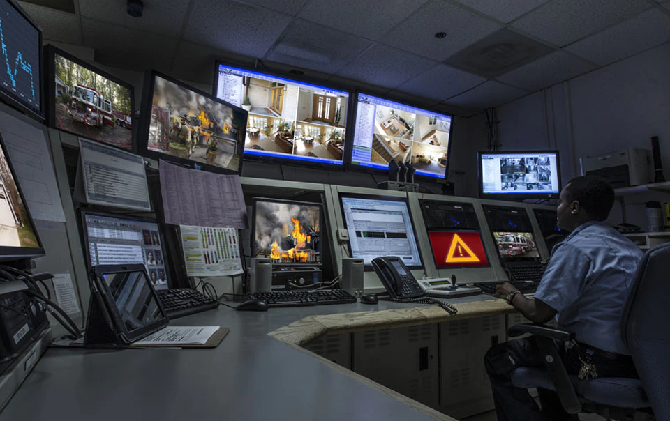 Person looking at multiple monitors using smart city technology.