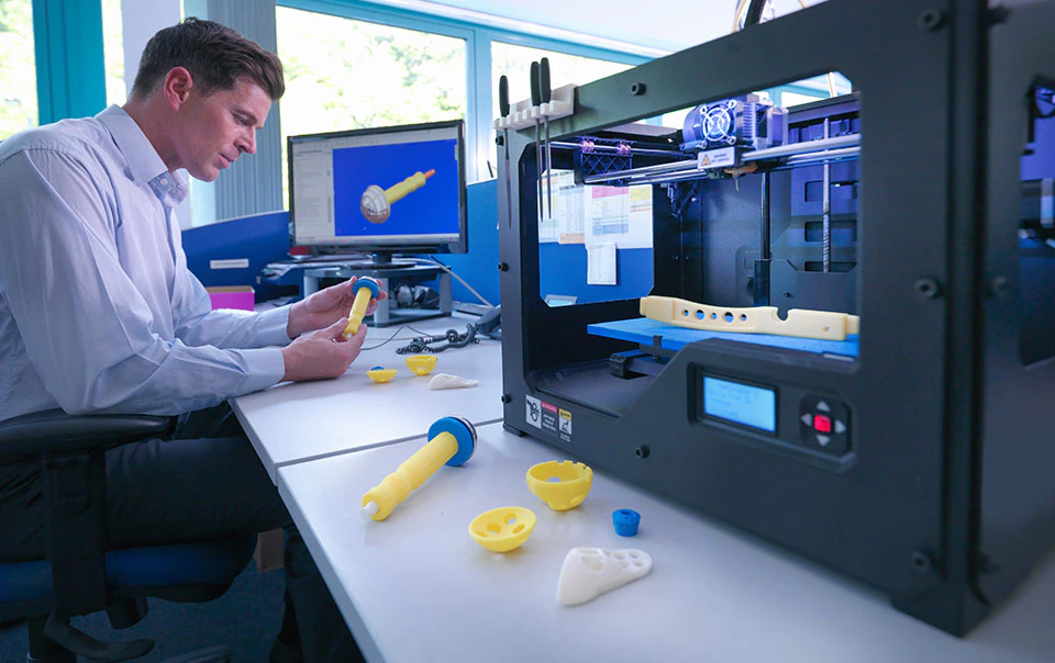 Worker examining 3D printing object.